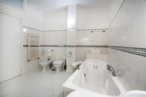 a white bathroom with a tub and a toilet at Hotel Belvedere in Conca dei Marini