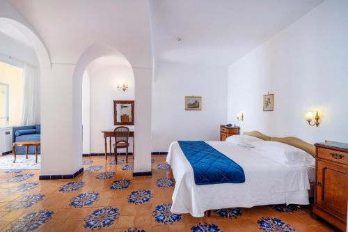 a bedroom with a bed and a table and chairs at Hotel Belvedere in Conca dei Marini
