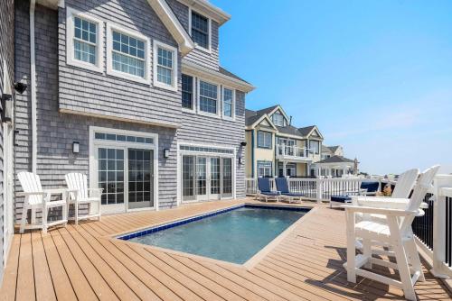 una casa con piscina su una terrazza in legno di Dunecrest by RoveTravel - Family Oceanfront with Heated Pool a Westhampton Beach