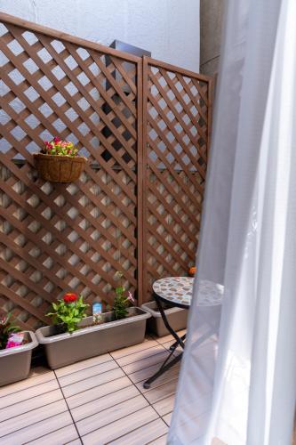 a wooden privacy fence with a table and potted plants at 両国駅前 in Tokyo