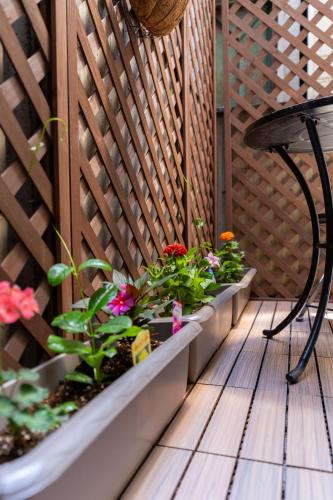 a patio with flowers and a chair on a wooden deck at 両国駅前 in Tokyo