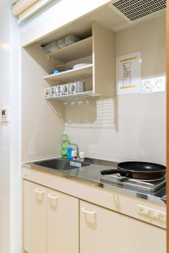 a kitchen with white cabinets and a sink at 両国駅前 in Tokyo