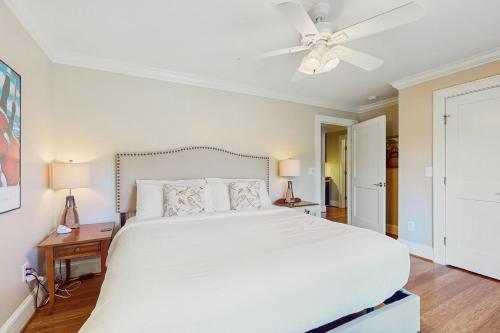 a bedroom with a large white bed and a ceiling fan at Lake Therapy in Lake Lure