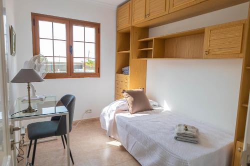 a bedroom with a bed and a desk with a chair at Brisa de Agaete in Puerto de las Nieves