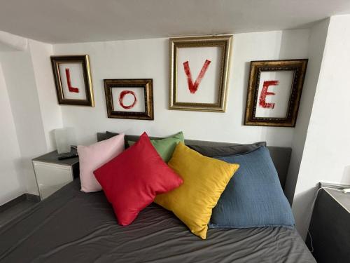 a room with a bed with colorful pillows on it at Loft 19 Luxury Suite Boutique - Heated pool in Los Cristianos