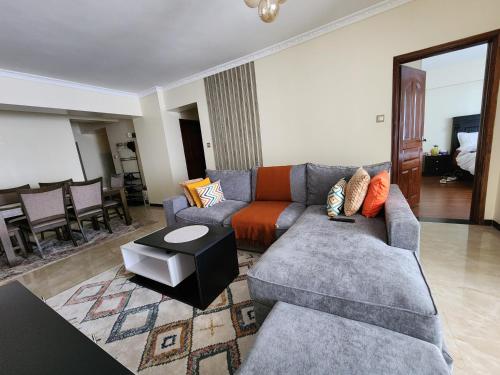 a living room with a couch and a table at Kilimani Quiet Skynest in Nairobi