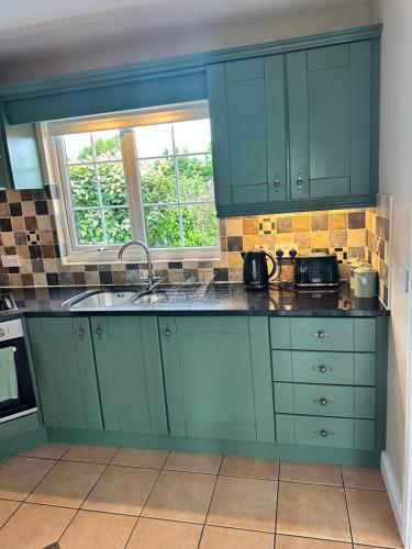 a kitchen with blue cabinets and a sink at The Holiday Home at 48b 