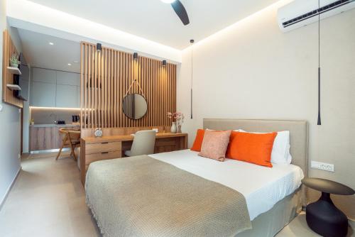a bedroom with a bed with orange pillows and a desk at Stylish Suite in Rhodes Town