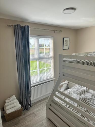 a bedroom with a bed and a window at The Holiday Home at 48b 