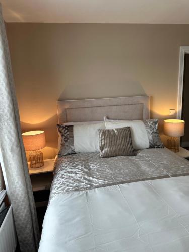 a bedroom with a large bed with two lamps at The Holiday Home at 48b 