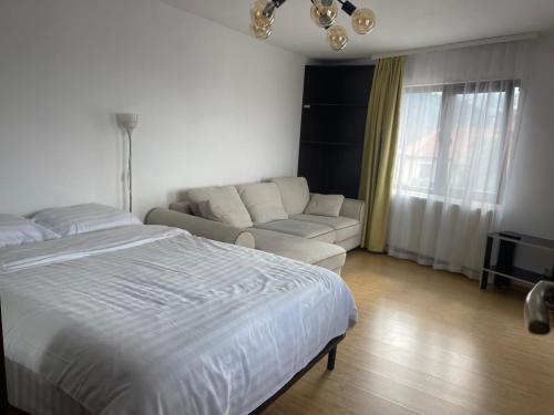 Un dormitorio blanco con una cama y un sofá. en Iza-bella 2, en Brasov