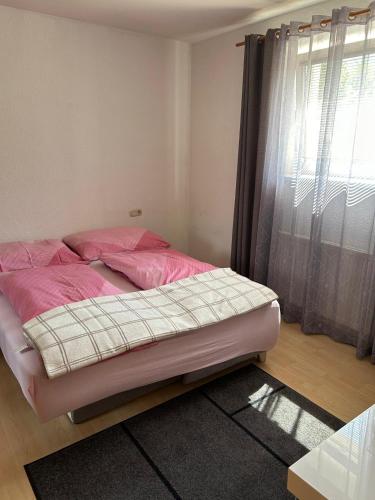 a bedroom with a bed with pink sheets and a window at Golger APP in Obervellach