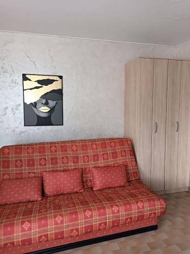 a red couch in a living room with a painting at Zevs Apartmani 1 in Igalo