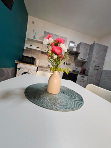 a vase with flowers on a table in a kitchen at Studio Apartments Pirandello 11 in Agrigento