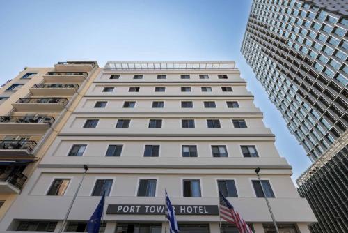 a tall white building with a port town hotel at Port Tower Piraeus in Piraeus