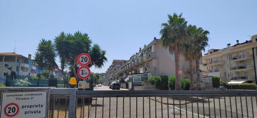 a gate in a street with palm trees and buildings at "Paradiso Due" Vasto Marina Appartamento a due passi dal mare in Vasto