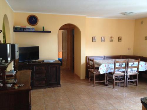 パンキアにあるAppartamento Bosco dei Veliのリビングルーム(テーブル、椅子、テレビ付)