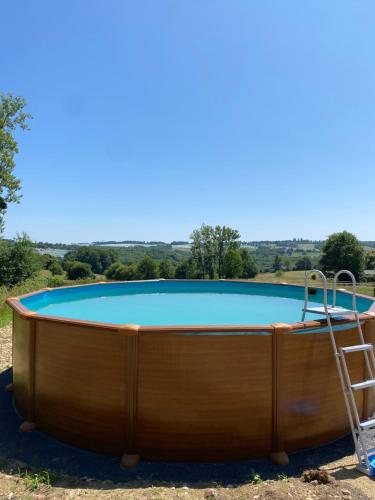 un trampoline et une échelle devant une piscine dans l'établissement The Llama Farm France, à Saint-Cyr-les-Champagnes
