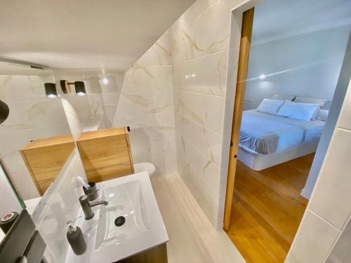 a small bathroom with a sink and a bed at Duplex 1 min de la plage in Beaulieu-sur-Mer