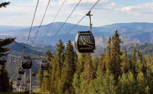 a group of gondolas on a ski lift in the mountains at New Listing Renovated 2 BR Aspen Condo in Aspen
