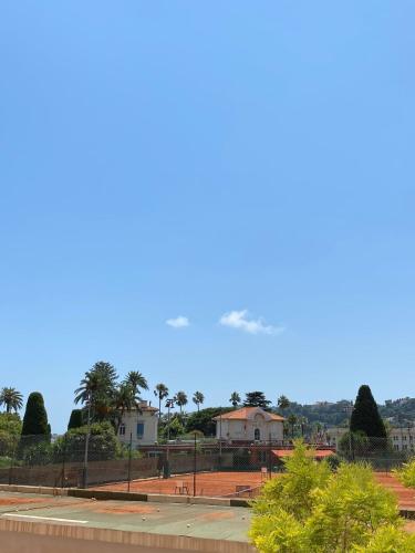 a plane flying in the sky over a park at Duplex 1 min de la plage in Beaulieu-sur-Mer