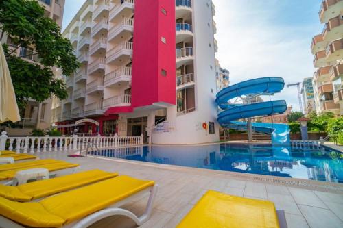 a swimming pool with a slide in front of a building at Bieno Club Svs Hotel in Alanya