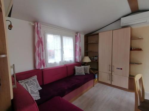 - un salon avec un canapé rouge et une fenêtre dans l'établissement MOBILHOME 40 m2 climatisé, domaine La Lande MIMIZAN, à Mimizan