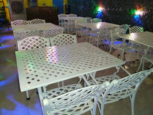 a white table and chairs in a restaurant at Modest Rooms By Libra in Khizrābād