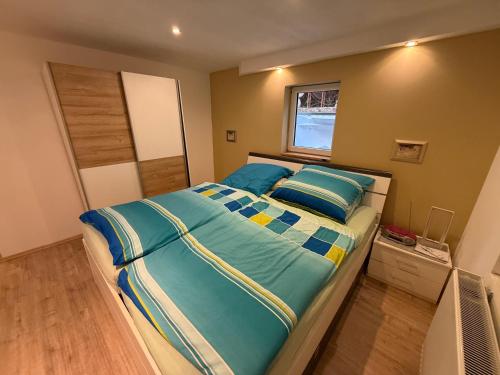 a bedroom with a bed with blue sheets and a window at Idyllische und ruhig gelegene 1ZKB Wohnung in Ludwigshafen am Rhein in Ludwigshafen am Rhein
