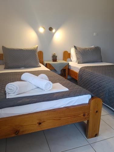 two beds in a room with towels on them at ΤΑ ΩΡΑΙΑ ΤΗΣ ΑΘΗΝΑς in Skala Mistegnon