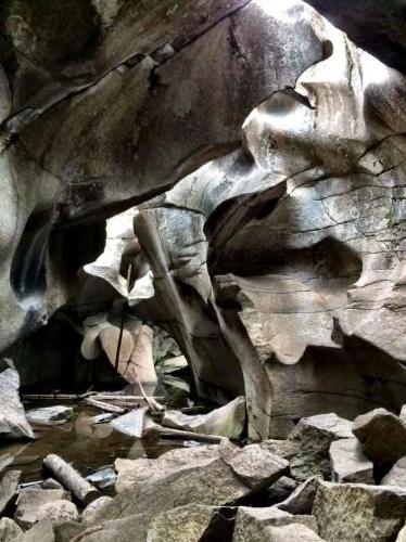 a rock wall with a stream of water at Fully Renovated 2 BR on River with Pool - Walk to Town! in Aspen