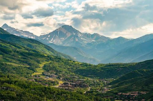 a town in a valley with mountains in the background at Fully Renovated 2 BR on River with Pool - Walk to Town! in Aspen
