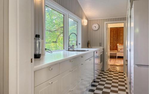 Una cocina con gabinetes blancos y piso a cuadros. en Lovely Home In Gilleleje With Wifi, en Gilleleje
