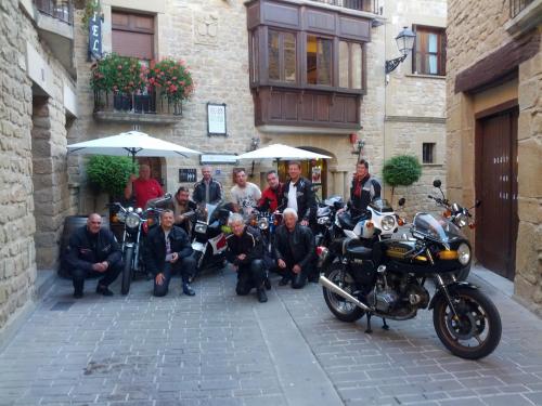 a group of people posing for a picture next to a motorcycle at Hotel Merindad de Olite in Olite