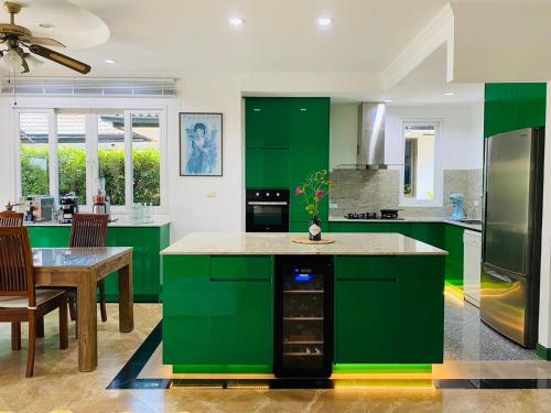 a large kitchen with green cabinets and a table at Hidden Villa Oasis Private Pool 2km to BeachMall in Hua Hin