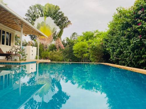 a swimming pool with blue water in front of a house at Hidden Villa Oasis Private Pool 2km to BeachMall in Hua Hin