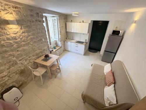 a living room with a table and a kitchen at Studio Appartment & Rooms Old Town in Rab