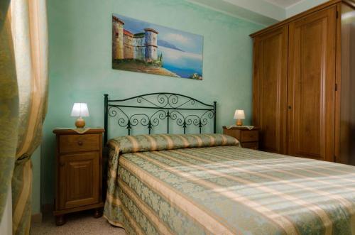 丽都玛里尼Residence Salù Lido Marini的一间卧室配有一张床和一个带两盏灯的梳妆台。