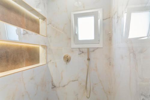 a bathroom with white marble walls and a window at Stathis Home in Exanthia