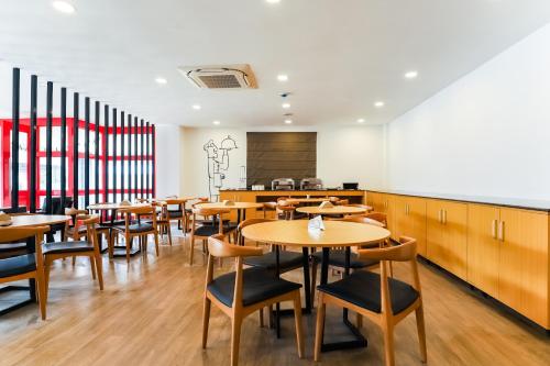 a dining room with wooden tables and chairs at Super Townhouse Prithvi Resort Near Phoenix Palassio in Lucknow