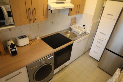 Il comprend une petite cuisine équipée d'un évier et d'un lave-vaisselle. dans l'établissement Magnifique studio emplacement premium, à Paris