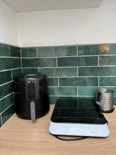 un grille-pain posé sur un comptoir à côté d'une cafetière dans l'établissement Lille, appartement de charme, à Lille