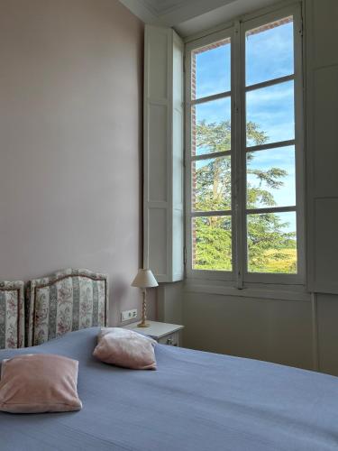 une chambre avec un lit bleu et une fenêtre dans l'établissement Chambre d'hôte double 2 au Château Lavalade, à Castelsarrasin
