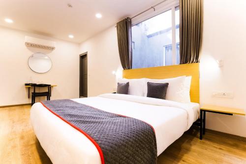 a hotel room with a bed and a window at Super Townhouse Prithvi Resort Near Phoenix Palassio in Lucknow