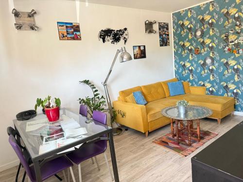 - un salon avec un canapé jaune et une table en verre dans l'établissement Sweet Home-PARKING GRATUIT - Appartement-proche centre ville-2 chambres, à Aix-en-Provence