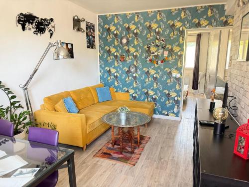un salon avec un canapé jaune et une table dans l'établissement Sweet Home-PARKING GRATUIT - Appartement-proche centre ville-2 chambres, à Aix-en-Provence