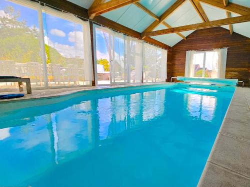 - une grande piscine d'eau bleue dans une maison dans l'établissement Villa Amiets, à Cléder