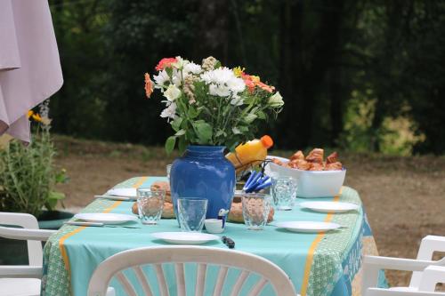 une table avec un vase bleu avec des fleurs dessus dans l'établissement Domme Villa 6 beds 8p secluded woodland with pool, à Florimont-Gaumiers