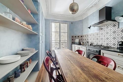 une cuisine avec une grande table en bois et des chaises rouges dans l'établissement Charming apartment near Pigalle & Montmartre, à Paris