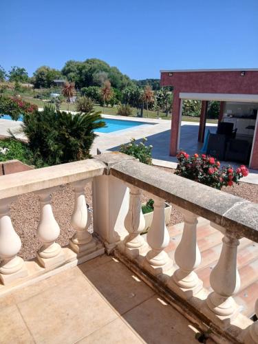 une clôture en pierre avec des fleurs et une piscine dans l'établissement Giuliani, à Le Pont du Travo